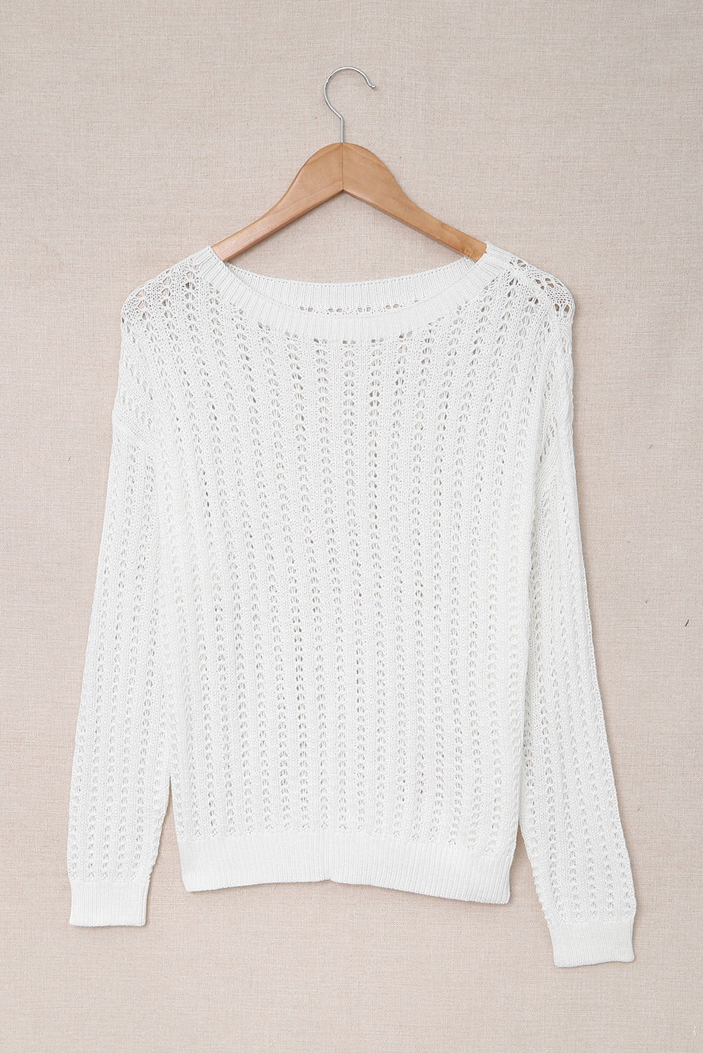 A stylish white knitted sweater featuring a hollow-out design and drop shoulder style, perfect for a chic and relaxed look.