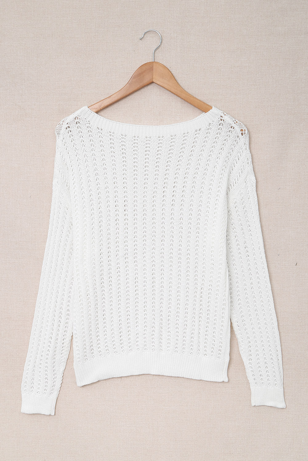 A stylish white knitted sweater featuring a hollow-out design and drop shoulder style, perfect for a chic and relaxed look.