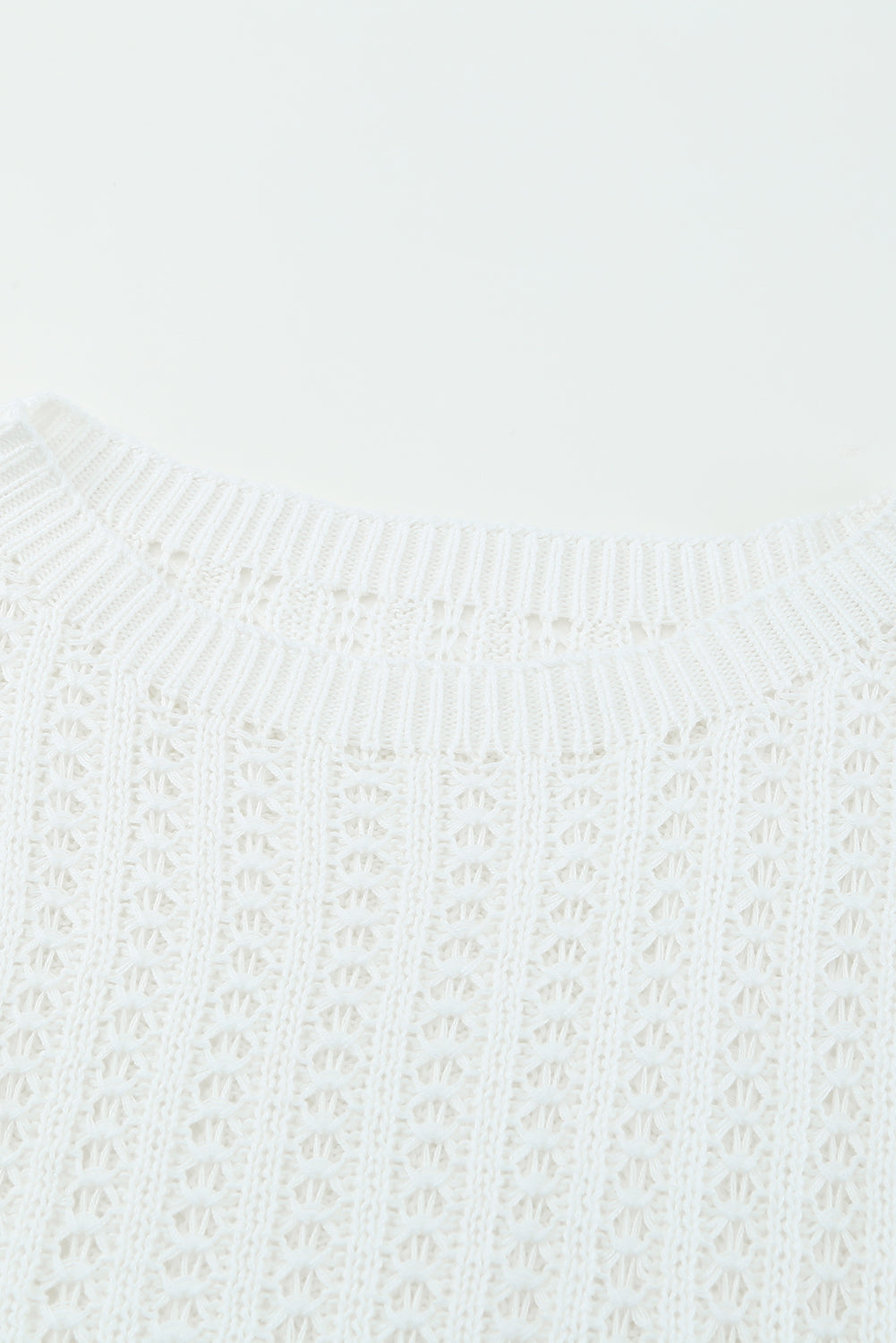 A stylish white knitted sweater featuring a hollow-out design and drop shoulder style, perfect for a chic and relaxed look.