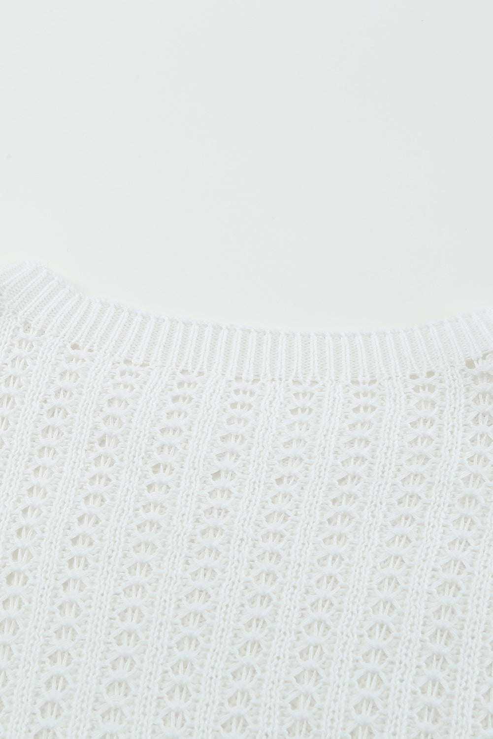 A stylish white knitted sweater featuring a hollow-out design and drop shoulder style, perfect for a chic and relaxed look.