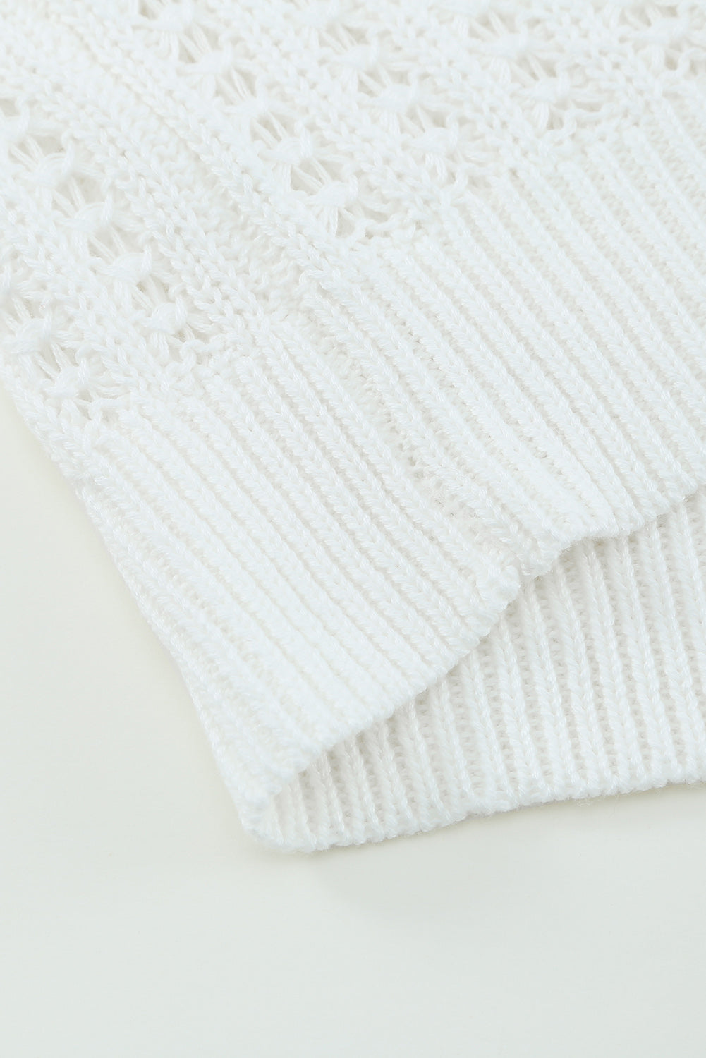 A stylish white knitted sweater featuring a hollow-out design and drop shoulder style, perfect for a chic and relaxed look.