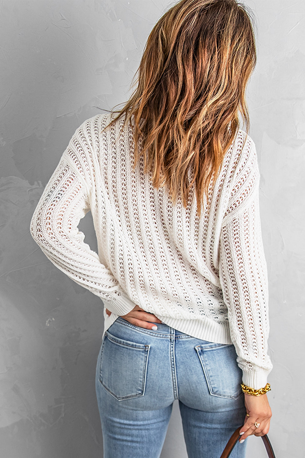 A stylish white knitted sweater featuring a hollow-out design and drop shoulder style, perfect for a chic and relaxed look.