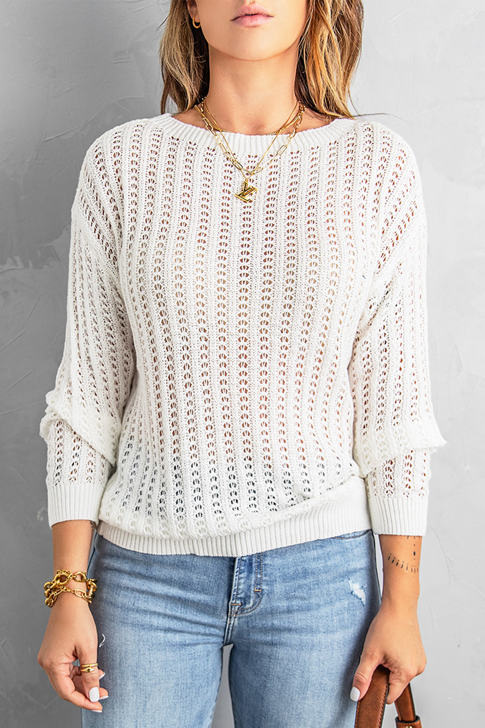 A stylish white knitted sweater featuring a hollow-out design and drop shoulder style, perfect for a chic and relaxed look.