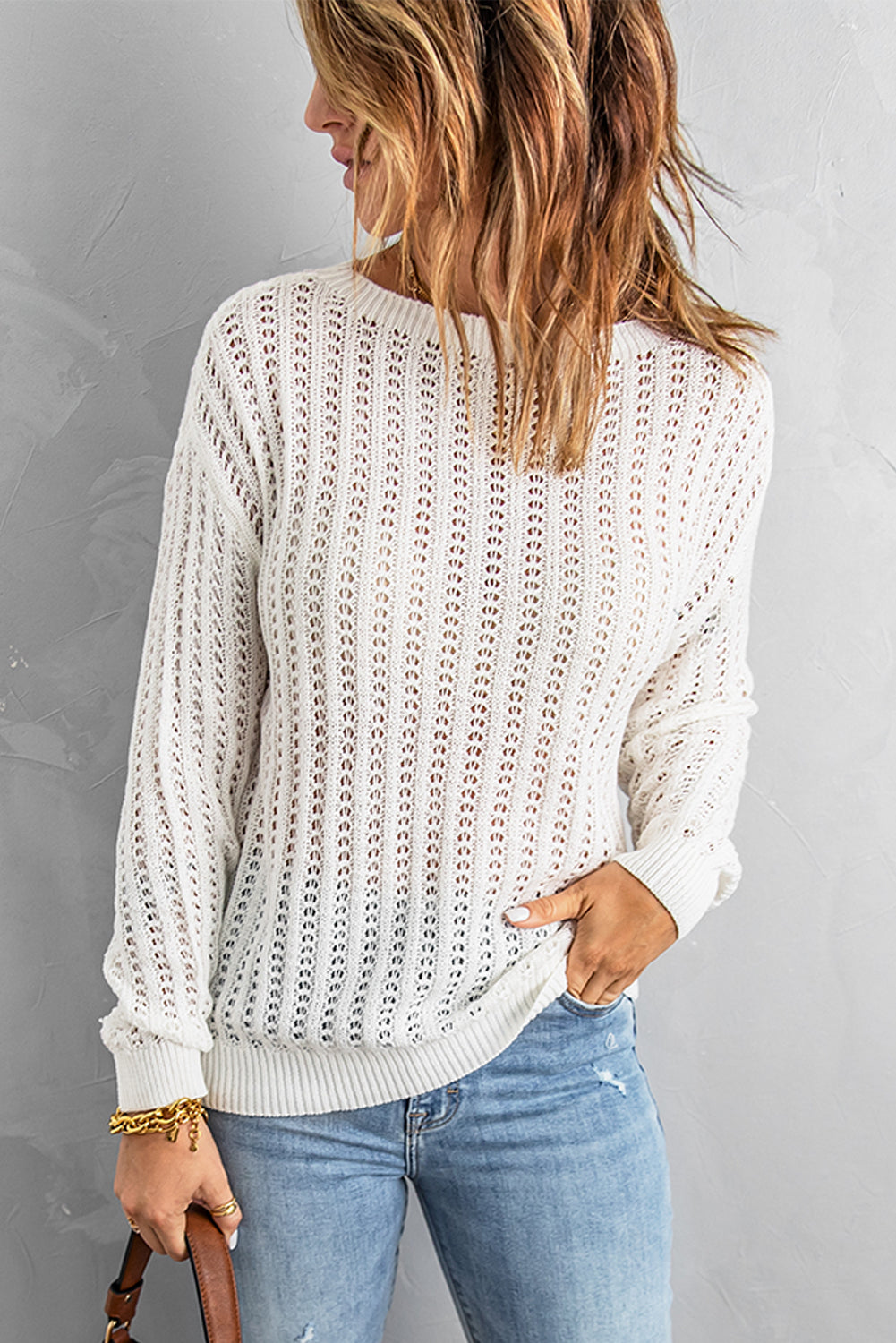 A stylish white knitted sweater featuring a hollow-out design and drop shoulder style, perfect for a chic and relaxed look.