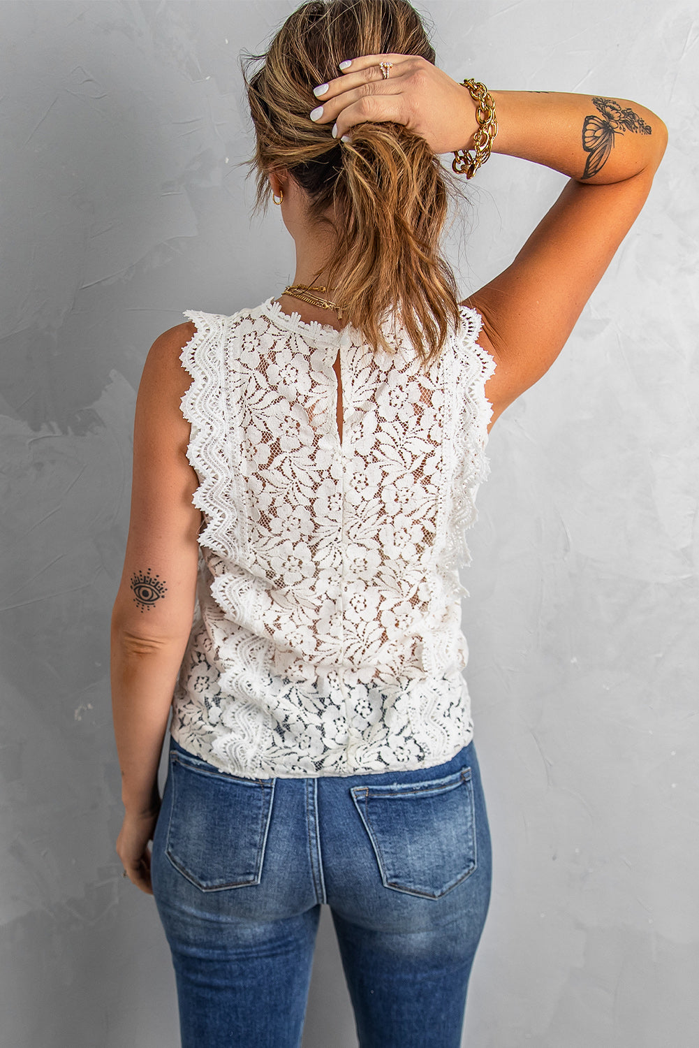 A stylish white lace v neck tank top featuring a delicate floral lace design, sleeveless cut, and a daring hollow-out back.