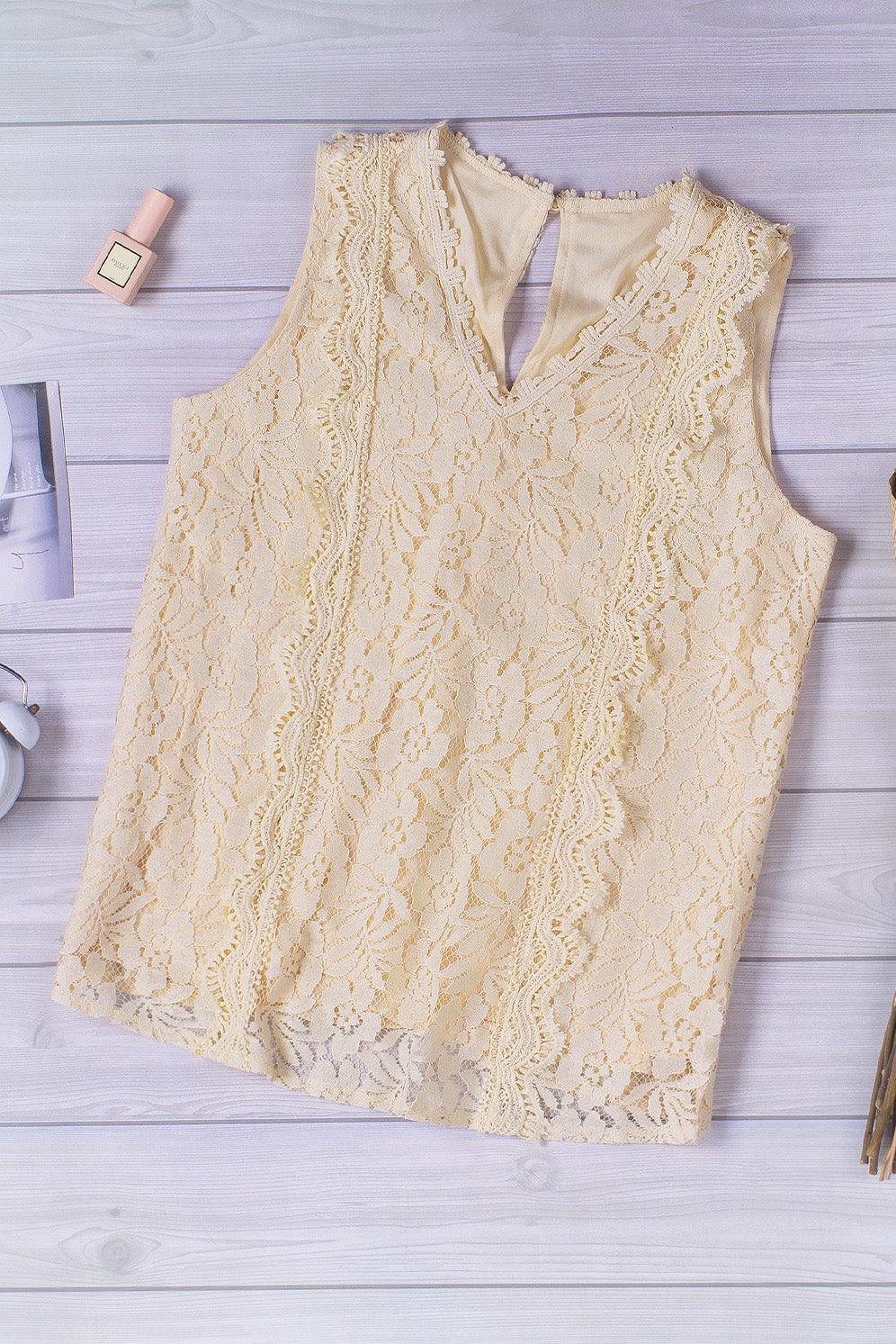 A stylish white lace v neck tank top featuring a delicate floral lace design, sleeveless cut, and a daring hollow-out back.