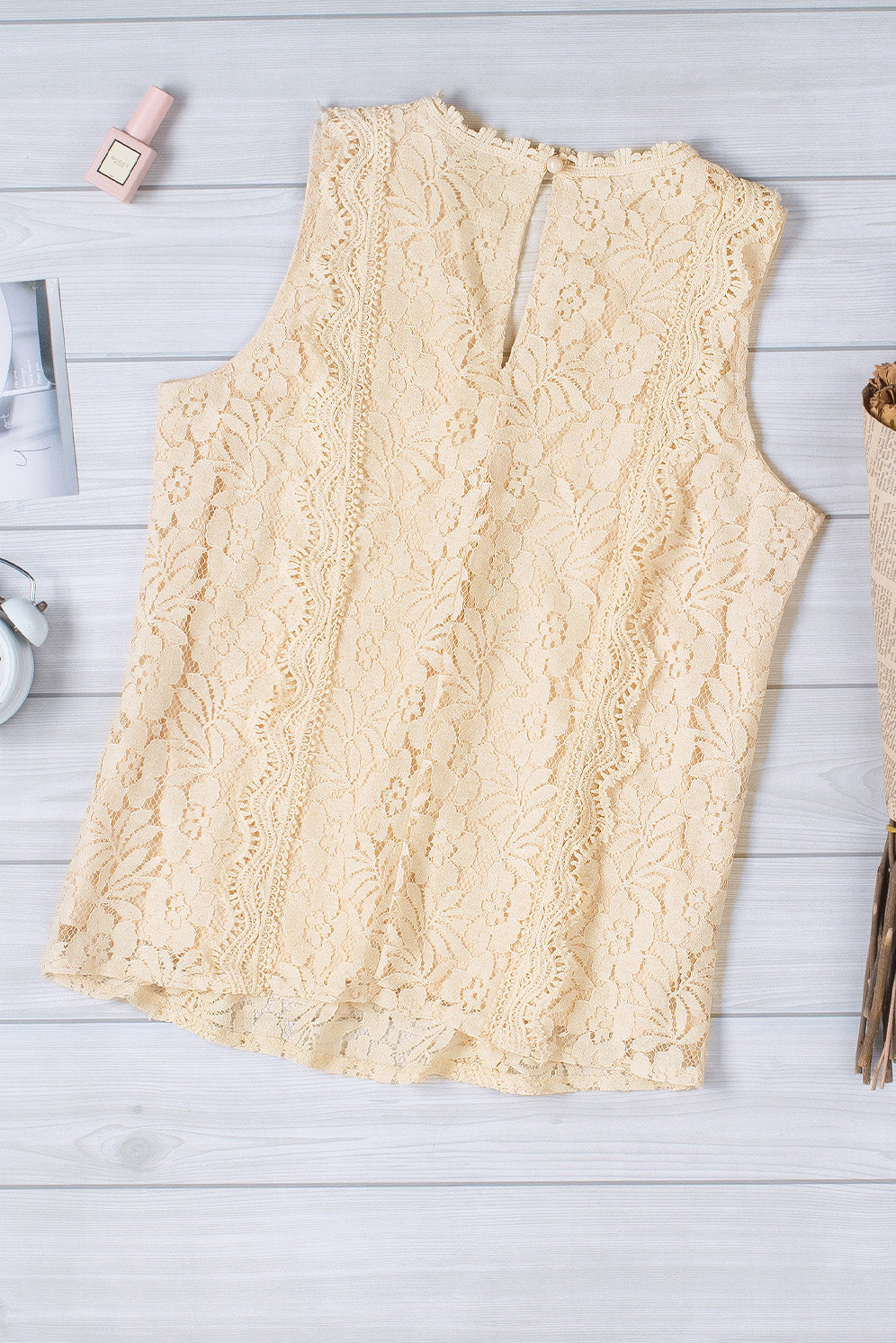 A stylish white lace v neck tank top featuring a delicate floral lace design, sleeveless cut, and a daring hollow-out back.