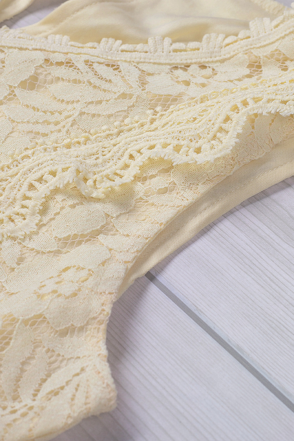 A stylish white lace v neck tank top featuring a delicate floral lace design, sleeveless cut, and a daring hollow-out back.