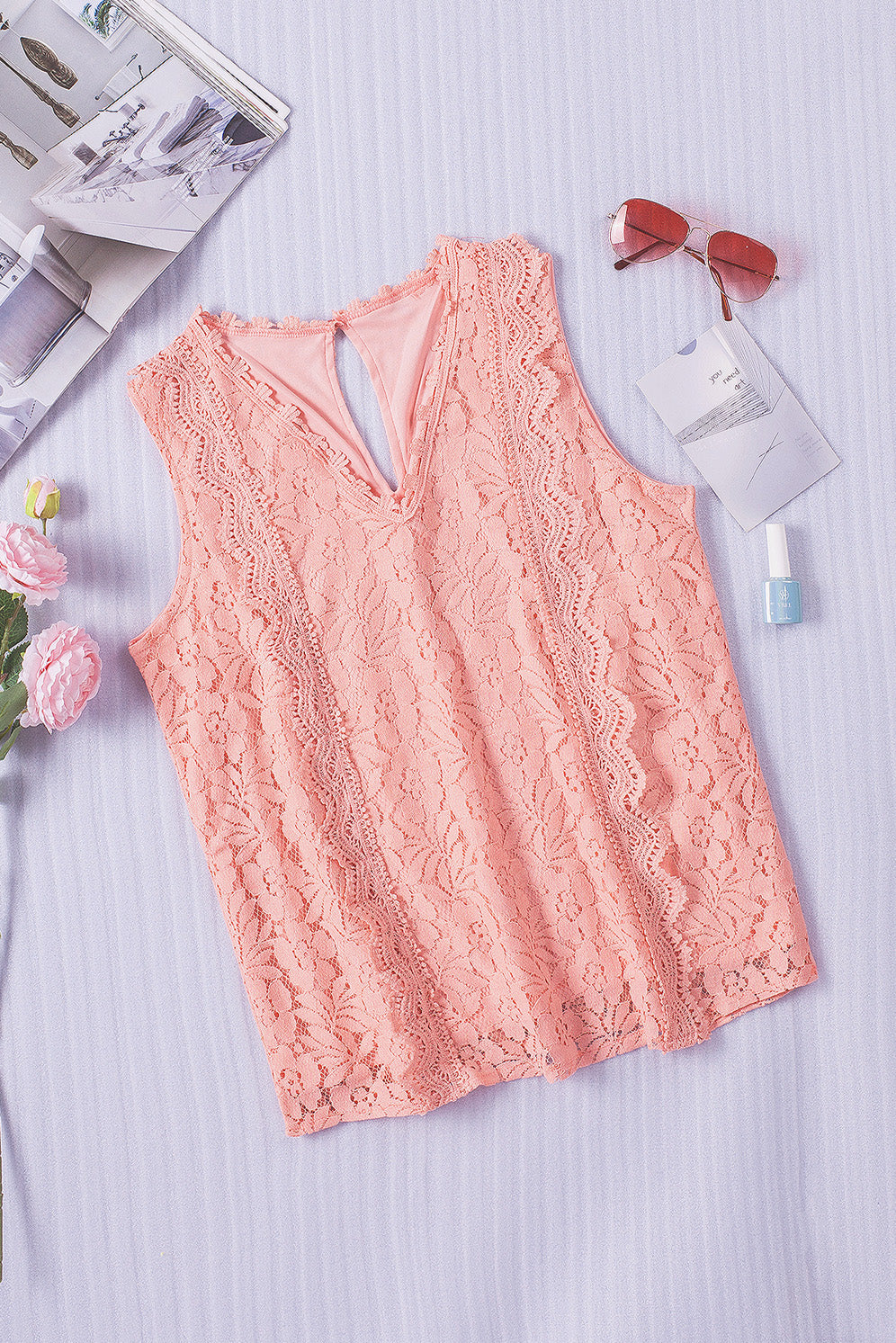 A stylish white lace v neck tank top featuring a delicate floral lace design, sleeveless cut, and a daring hollow-out back.