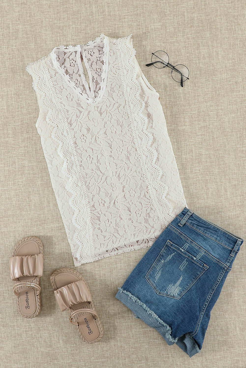 A stylish white lace v neck tank top featuring a delicate floral lace design, sleeveless cut, and a daring hollow-out back.