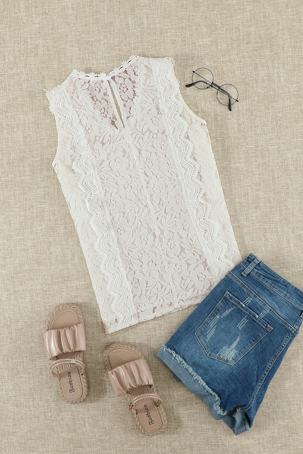 A stylish white lace v neck tank top featuring a delicate floral lace design, sleeveless cut, and a daring hollow-out back.