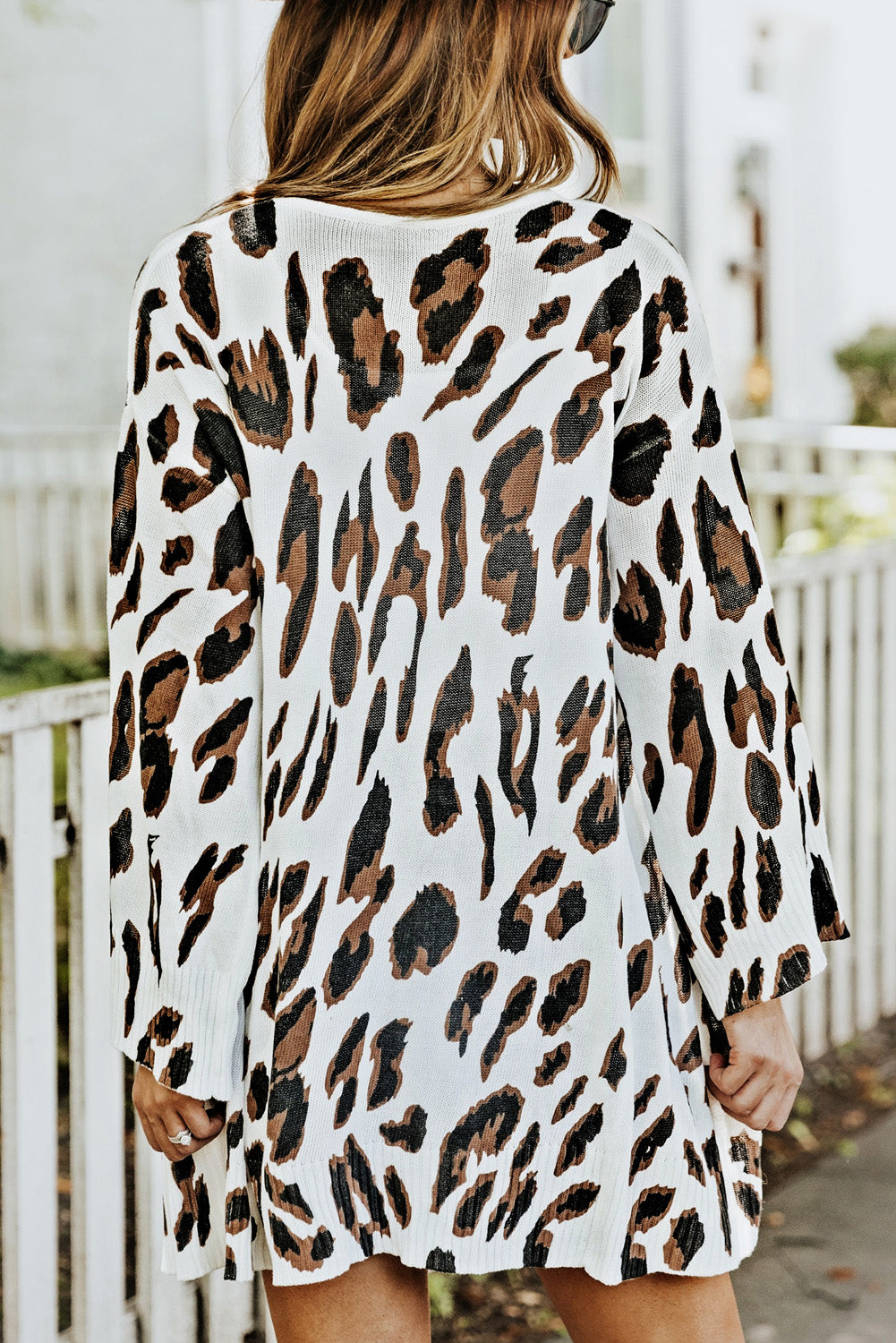 A stylish white cardigan featuring a leopard print design, bell sleeves, and an open front, perfect for autumn fashion.