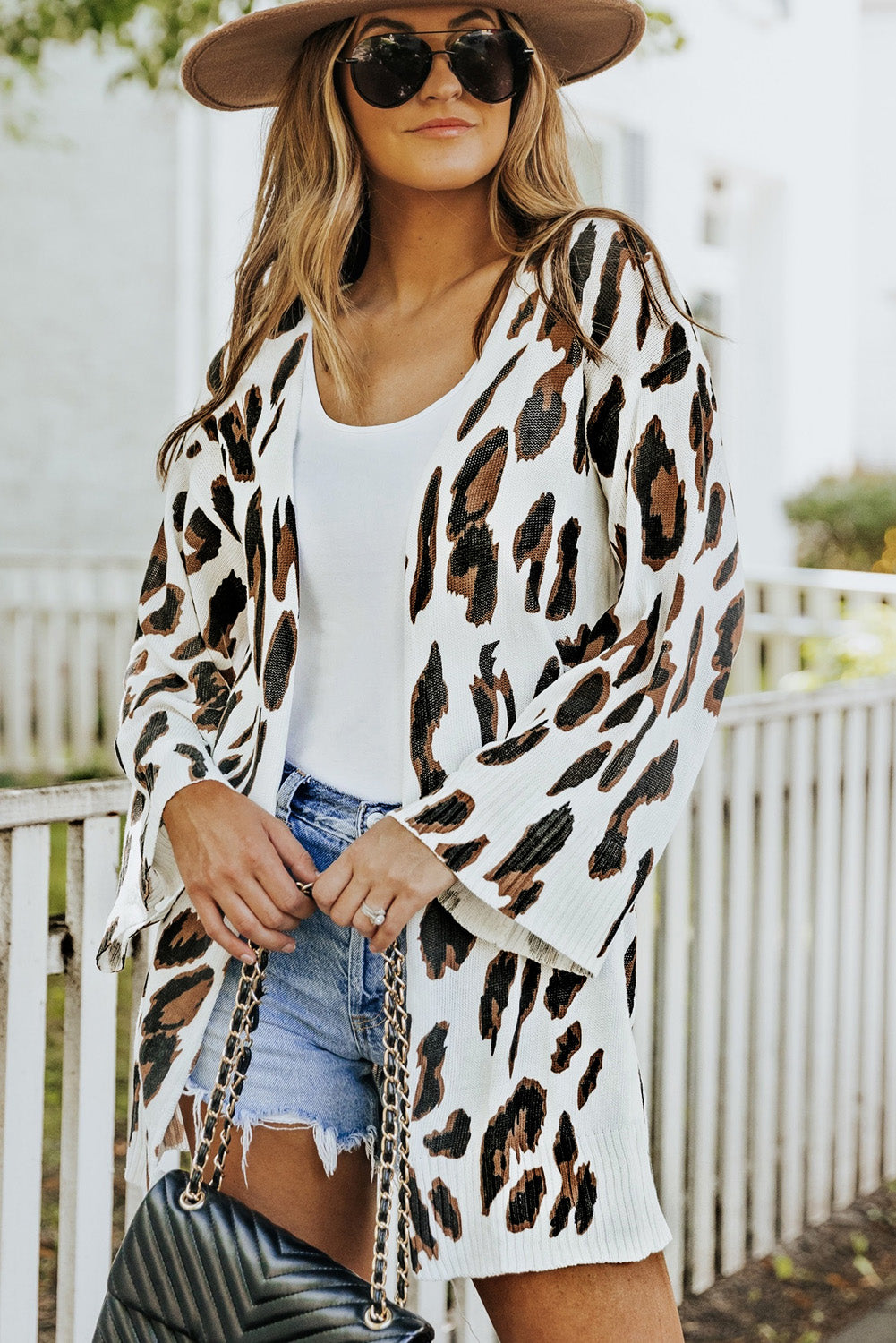 A stylish white cardigan featuring a leopard print design, bell sleeves, and an open front, perfect for autumn fashion.