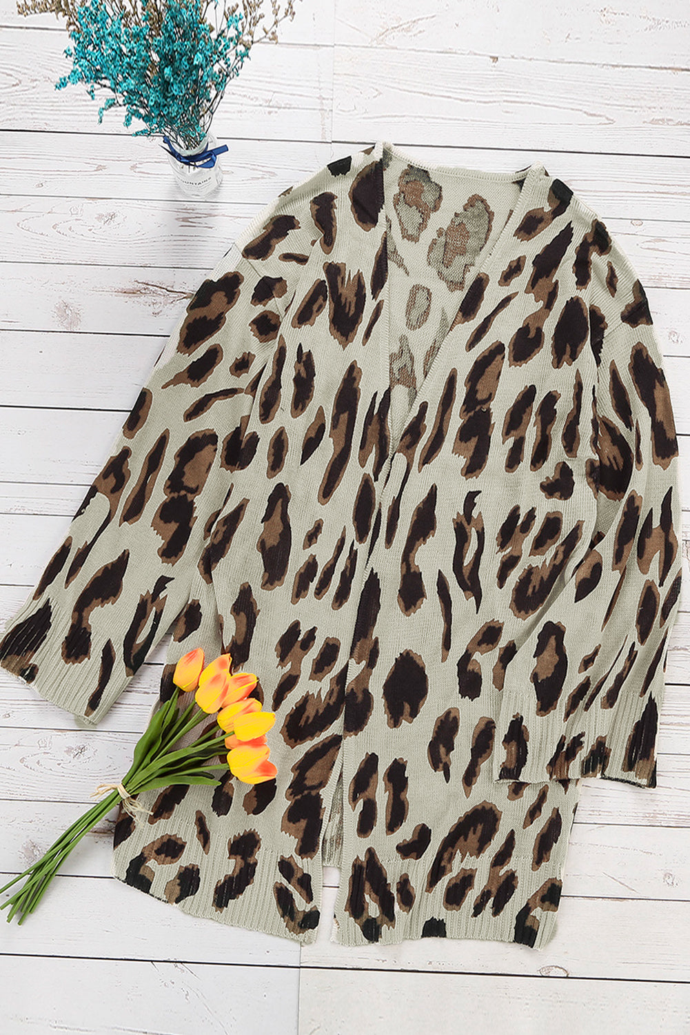 A stylish white cardigan featuring a leopard print design, bell sleeves, and an open front, perfect for autumn fashion.