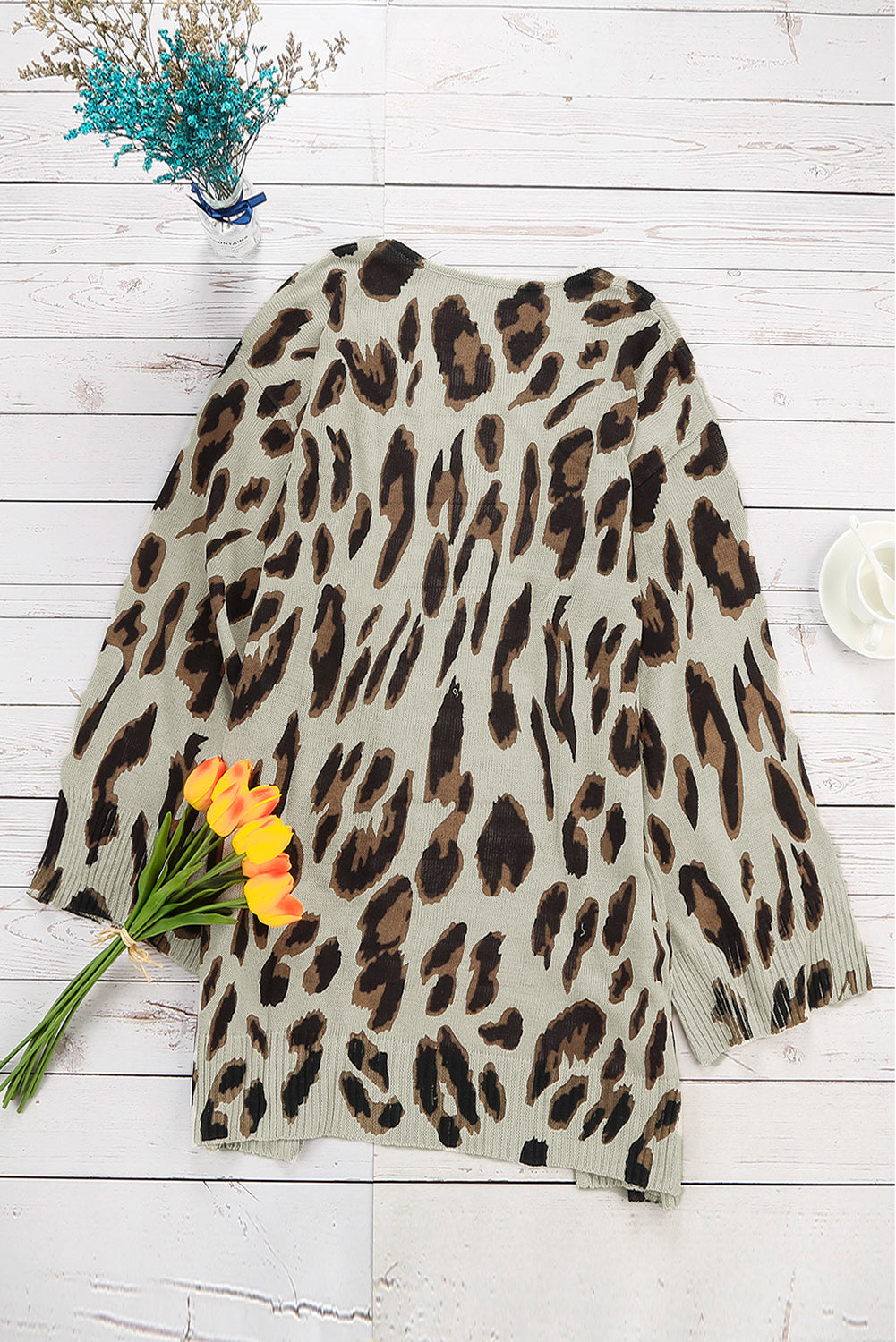 A stylish white cardigan featuring a leopard print design, bell sleeves, and an open front, perfect for autumn fashion.