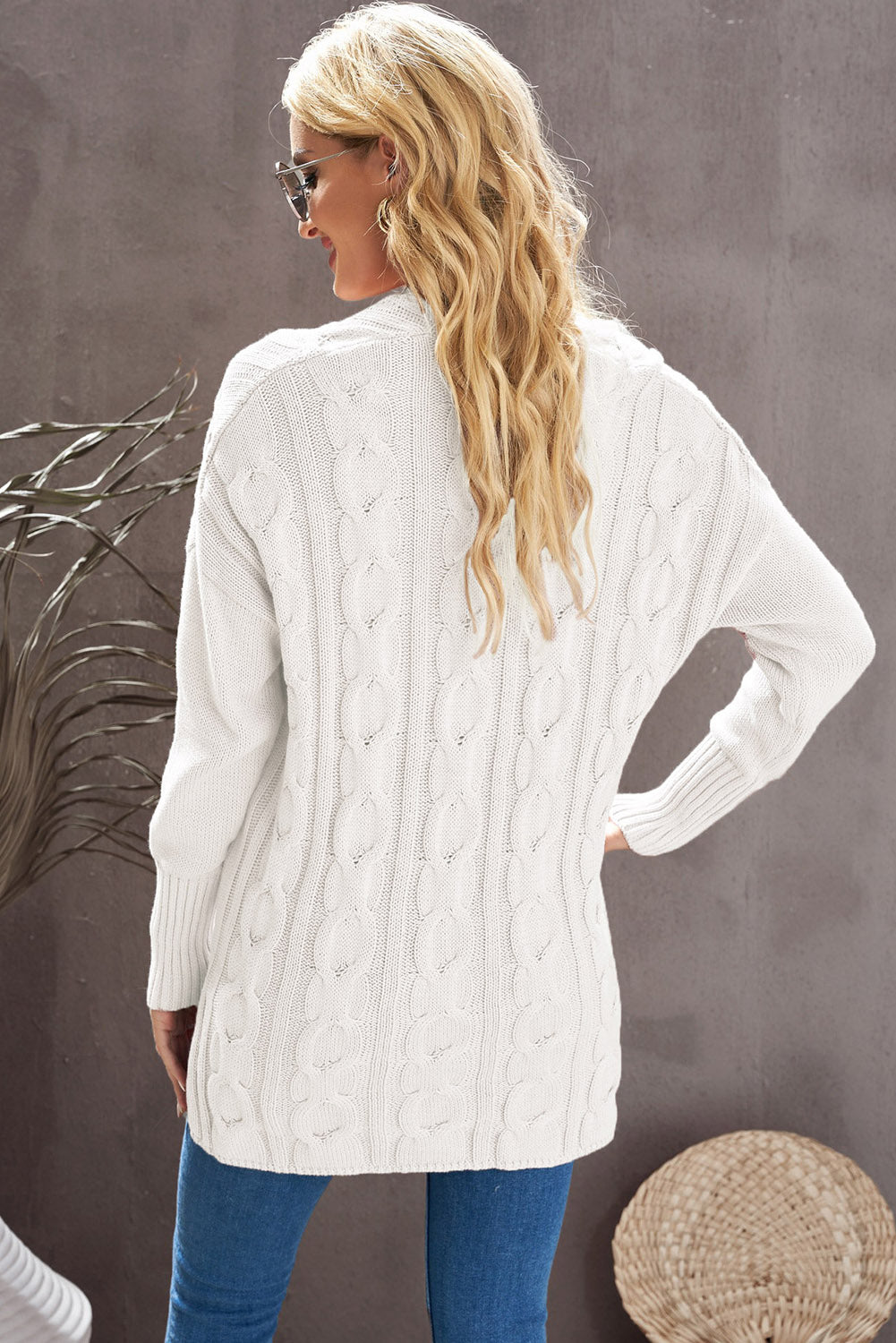 A stylish white oversized knit sweater with a deep v-neck and side slits, perfect for cozy wear.