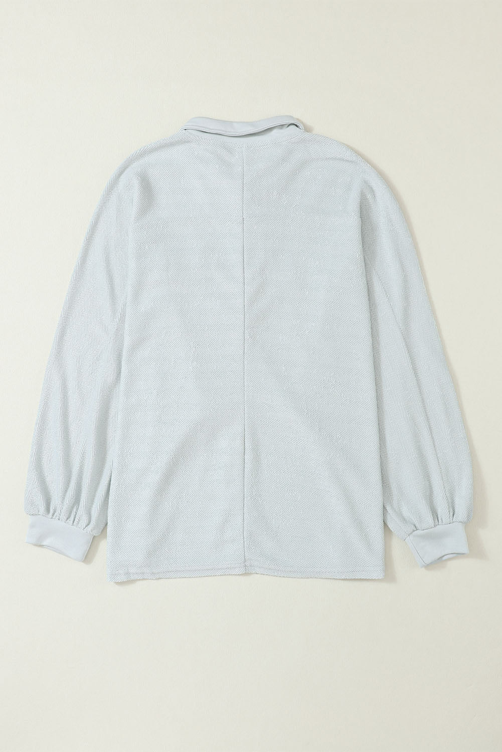 A stylish white oversized sweatshirt featuring flap pockets, a button collared neck, and loose sleeves, perfect for casual wear.