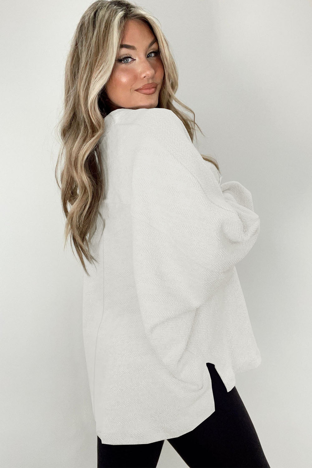 A stylish white oversized sweatshirt featuring flap pockets, a button collared neck, and loose sleeves, perfect for casual wear.