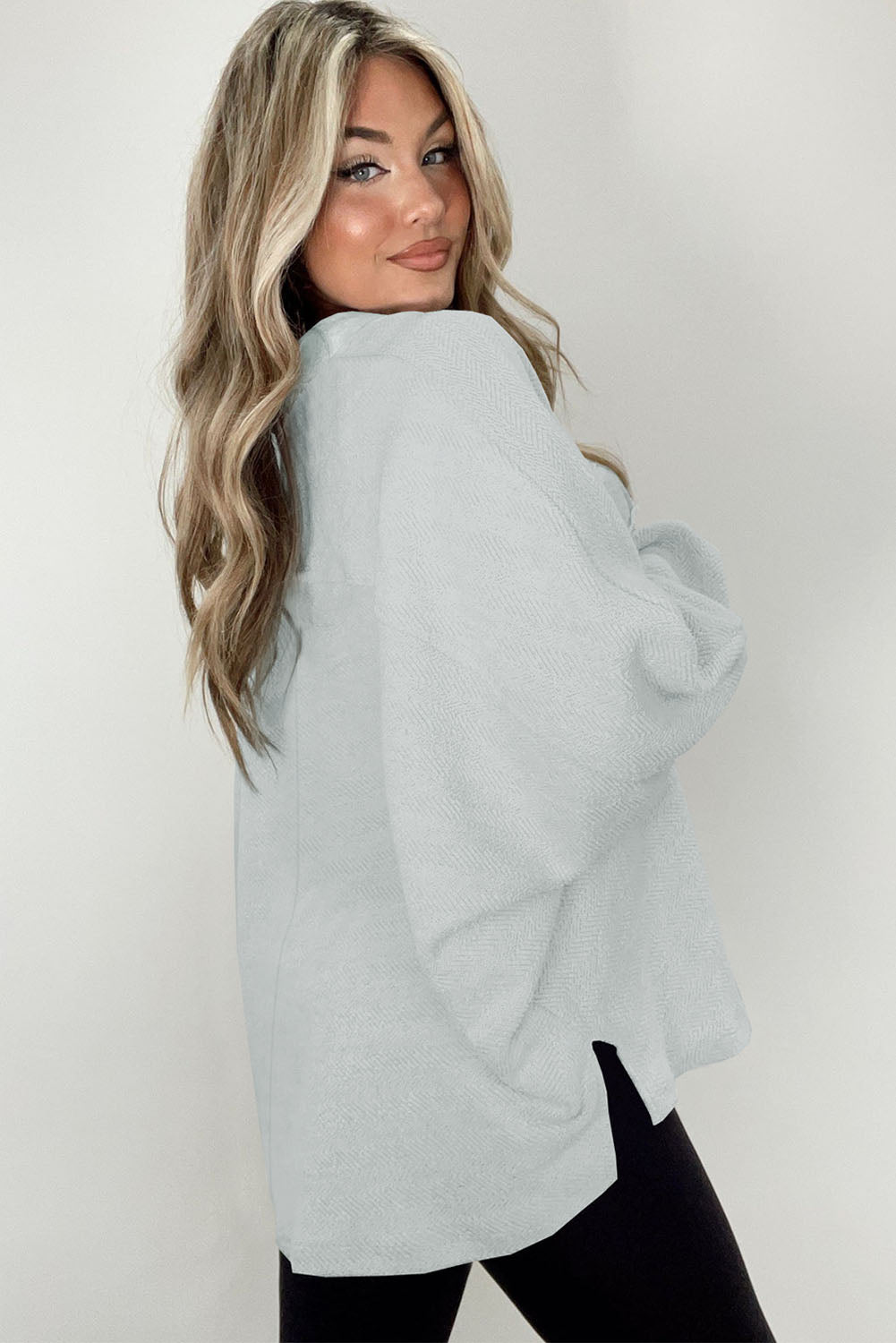 A stylish white oversized sweatshirt featuring flap pockets, a button collared neck, and loose sleeves, perfect for casual wear.