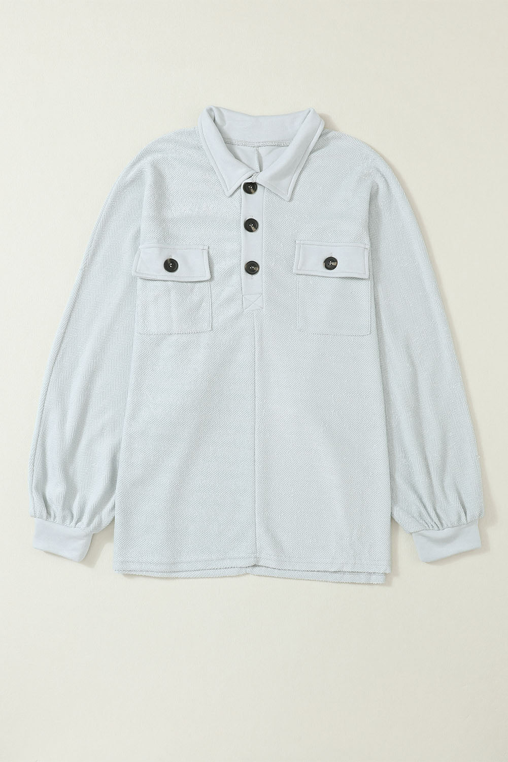 A stylish white oversized sweatshirt featuring flap pockets, a button collared neck, and loose sleeves, perfect for casual wear.