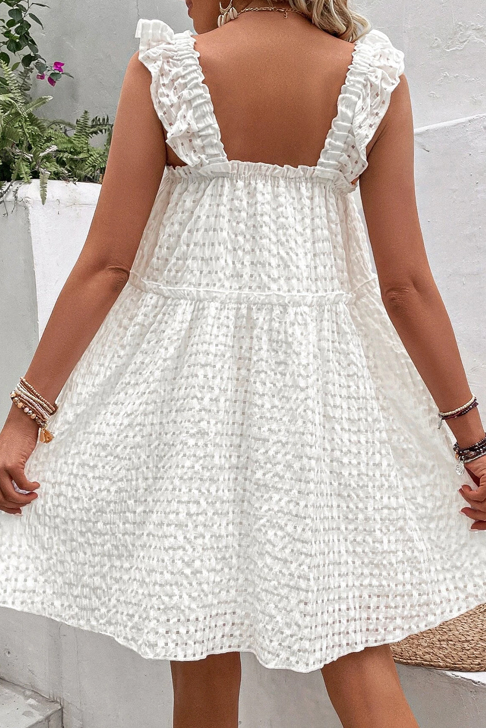 A stylish white plaid sleeveless dress with ruffled straps, perfect for summer outings.