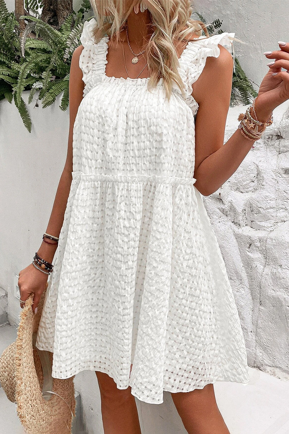 A stylish white plaid sleeveless dress with ruffled straps, perfect for summer outings.