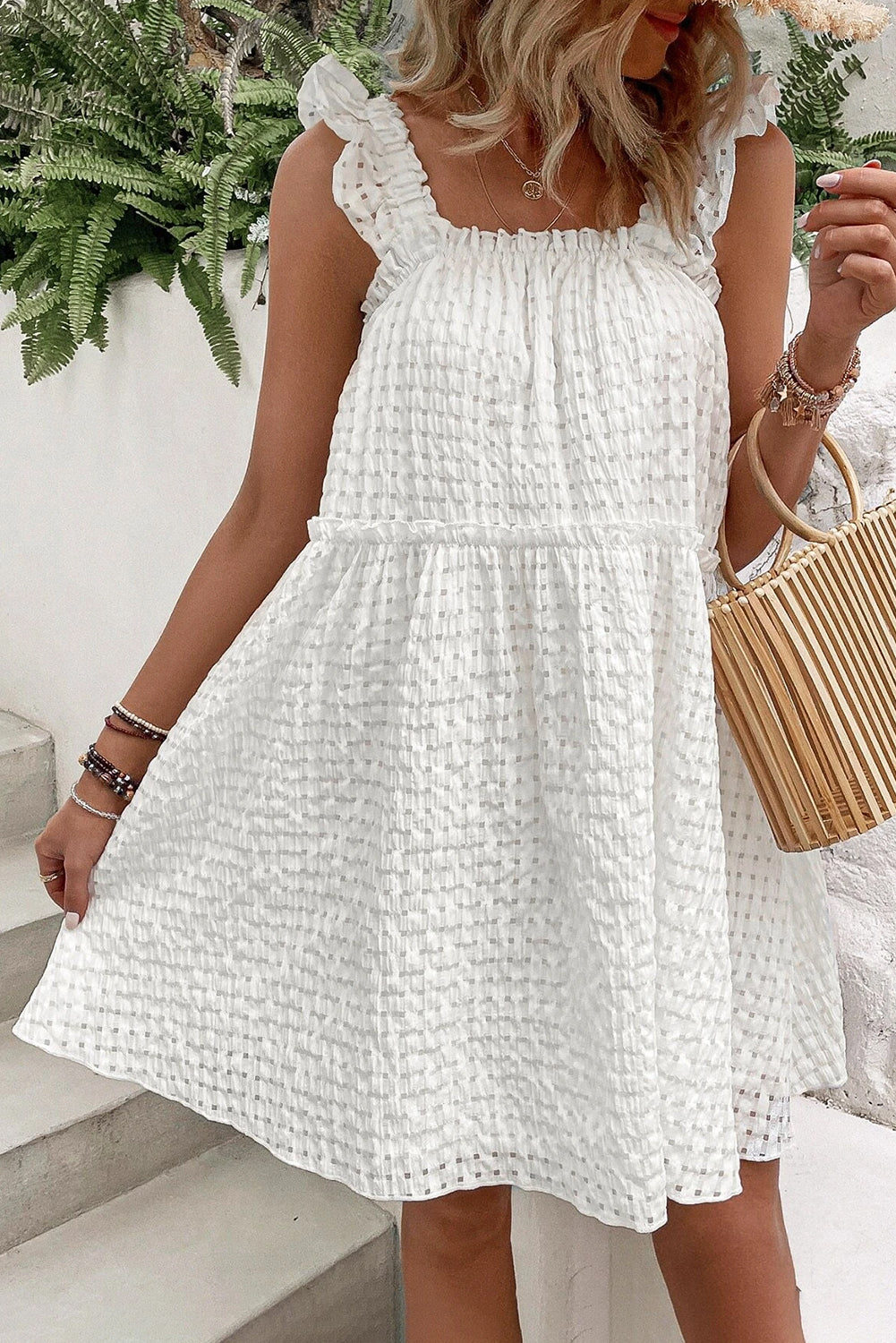 A stylish white plaid sleeveless dress with ruffled straps, perfect for summer outings.