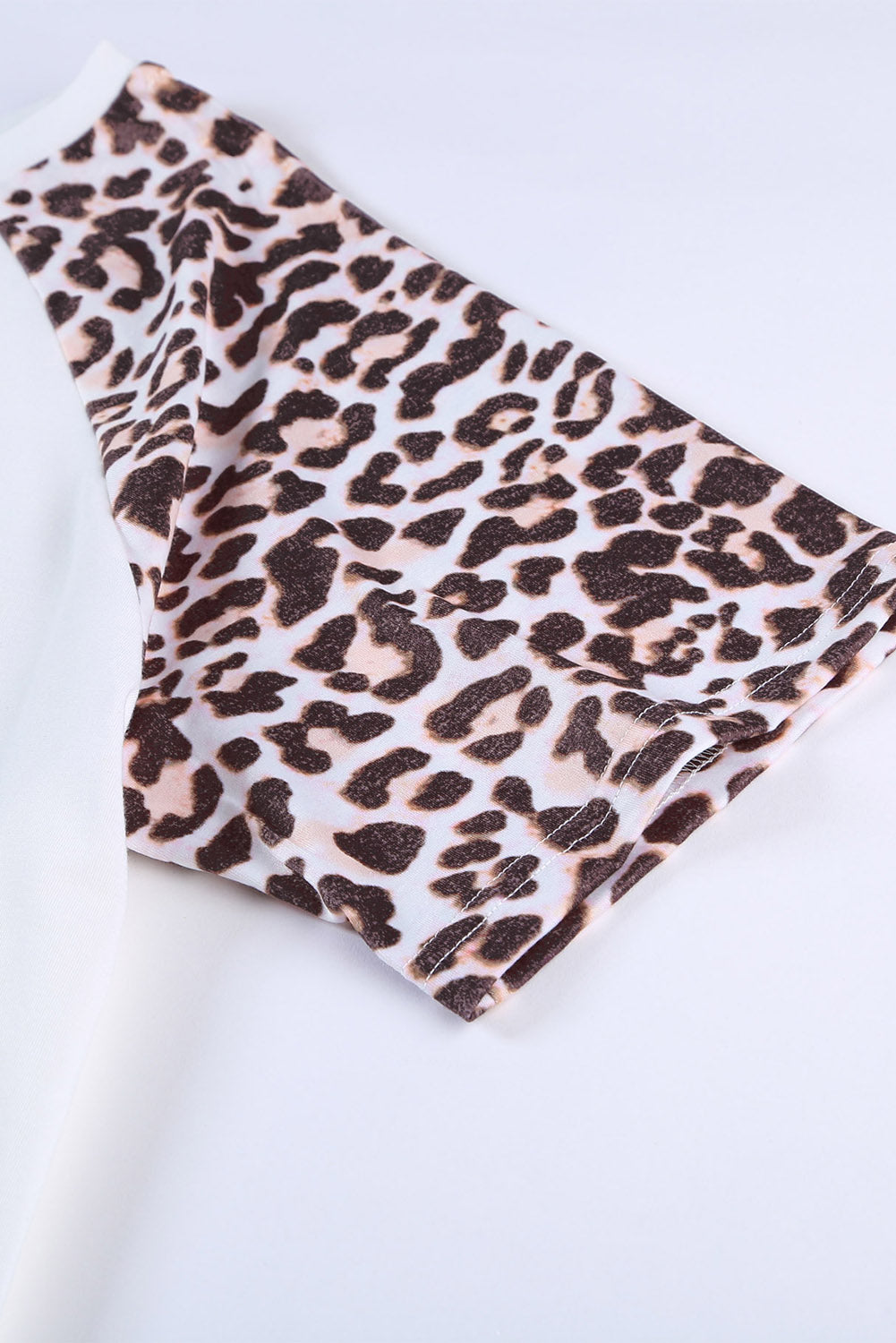 White plus size double pocket top featuring a chic leopard print and color block design, perfect for casual wear.