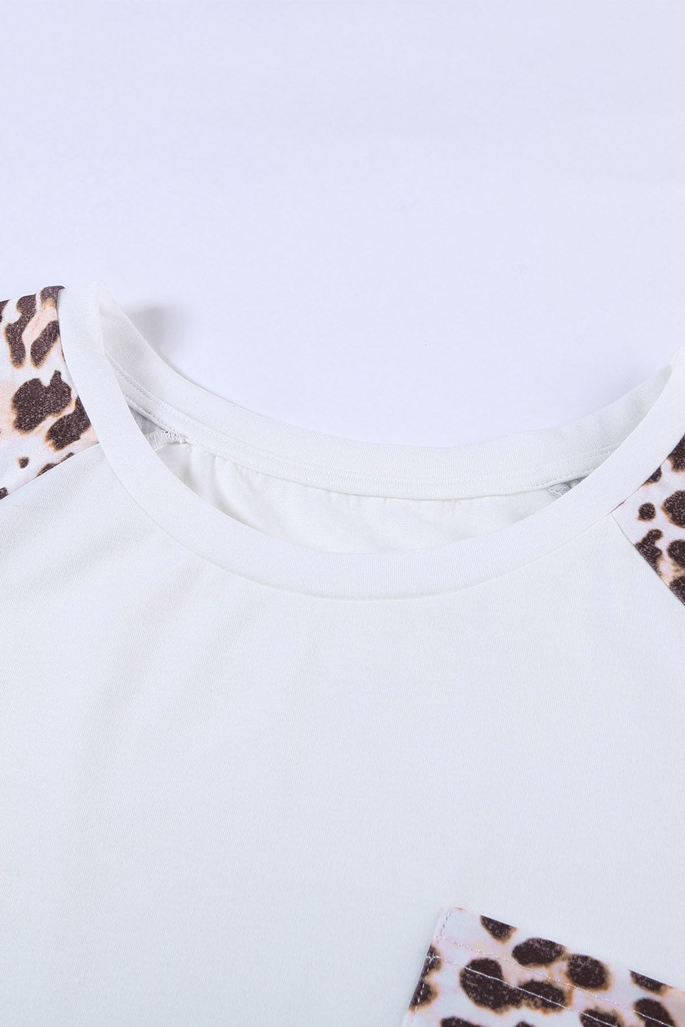 White plus size double pocket top featuring a chic leopard print and color block design, perfect for casual wear.