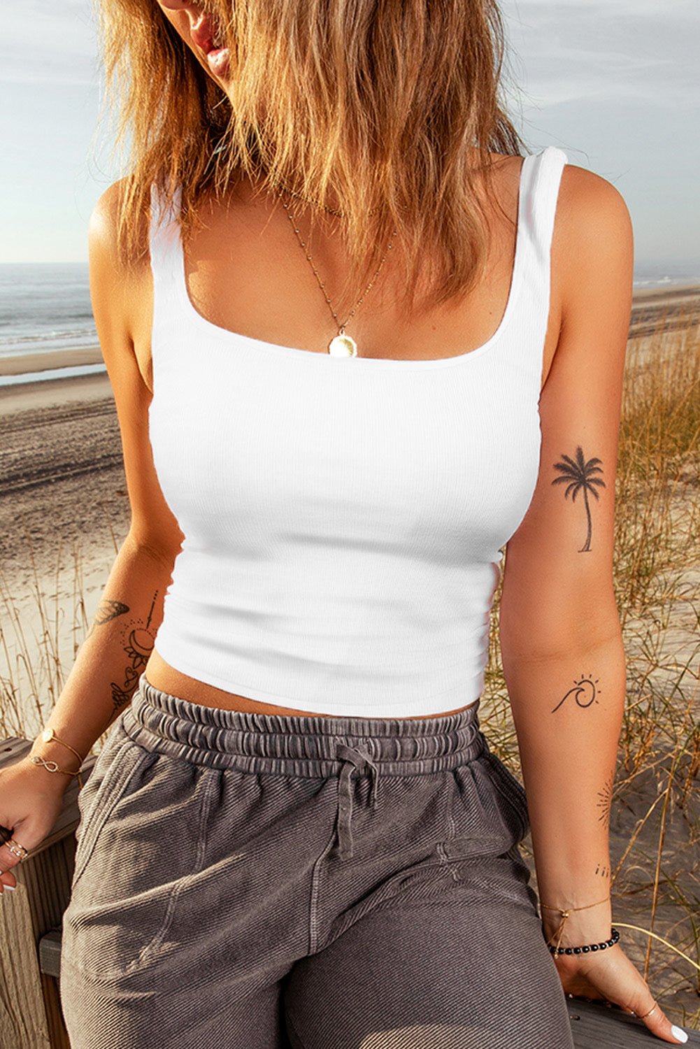 A stylish white ribbed knit skinny tank top with a square neckline, showcasing its textured fabric and flattering fit.