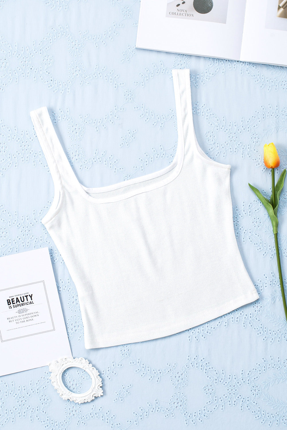 A stylish white ribbed knit skinny tank top with a square neckline, showcasing its textured fabric and flattering fit.