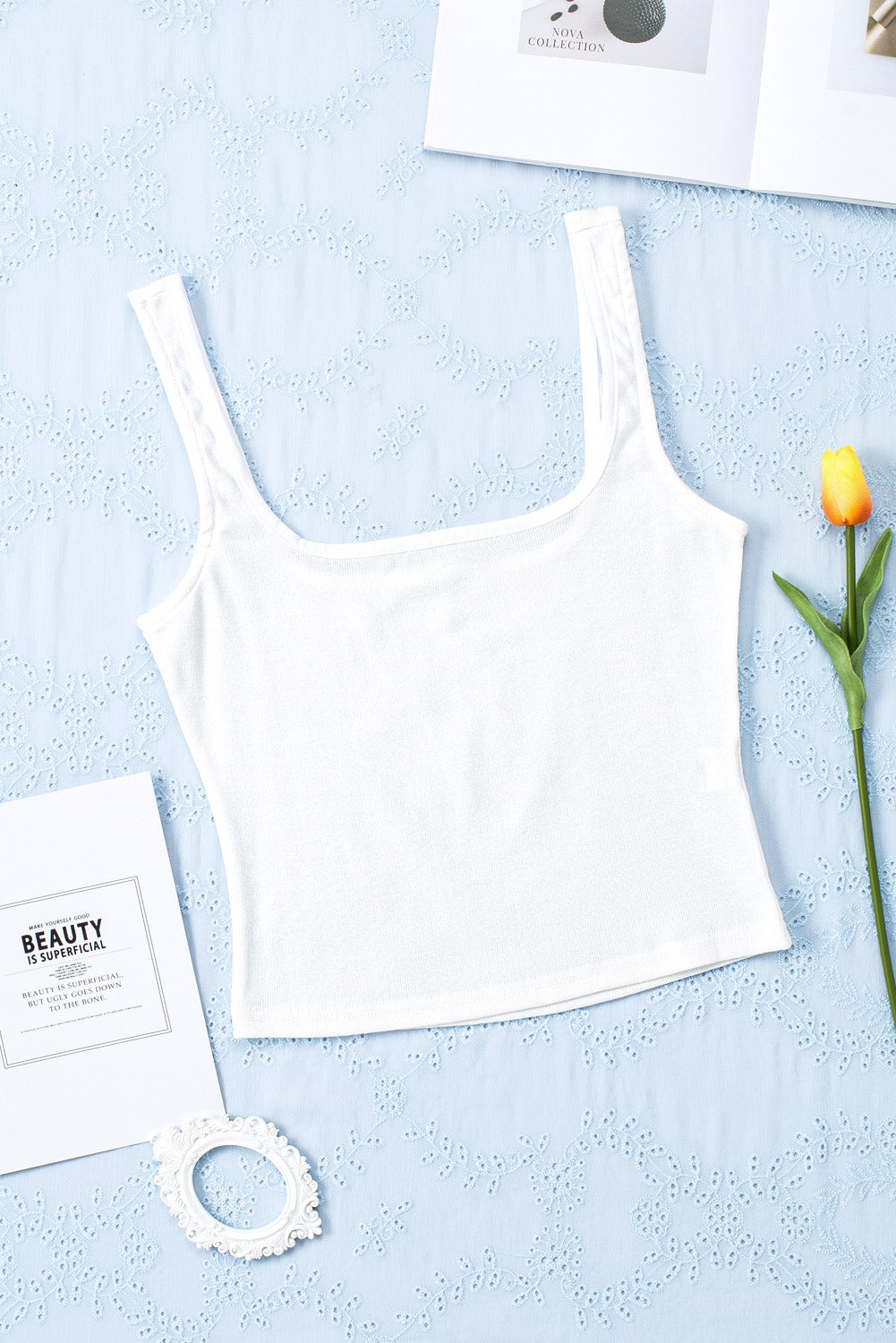 A stylish white ribbed knit skinny tank top with a square neckline, showcasing its textured fabric and flattering fit.