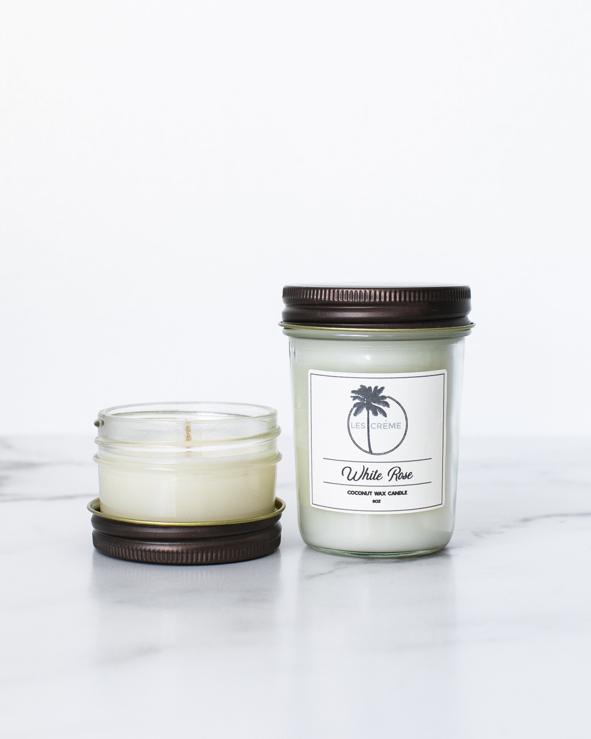 A beautifully crafted White Rose Scent Coconut Wax Candle in a glass jar, showcasing its elegant design and natural ingredients.