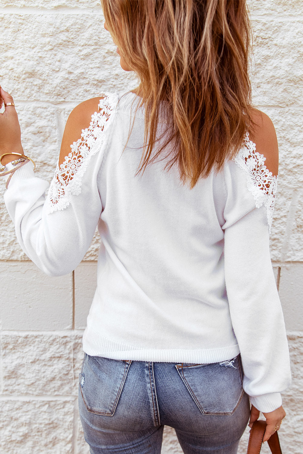 A stylish white round neck sweater featuring cold shoulder design and delicate lace splicing, perfect for chic casual wear.