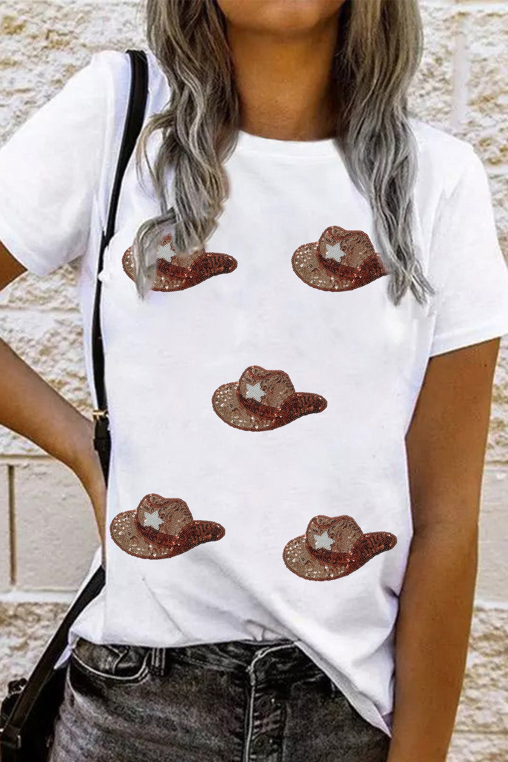 White t-shirt featuring a graphic of cowgirl hats embellished with sequins, perfect for casual wear.