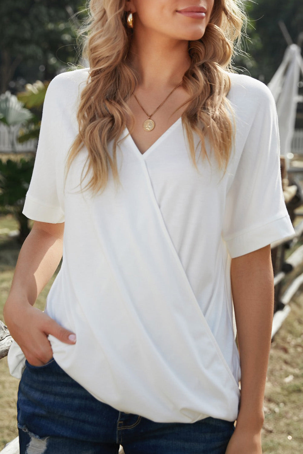 White short sleeves drape knit top with v-neckline and cuffed sleeves, showcasing a chic hi-lo hem design.