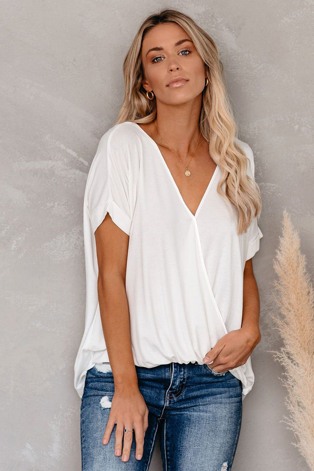 White short sleeves drape knit top with v-neckline and cuffed sleeves, showcasing a chic hi-lo hem design.