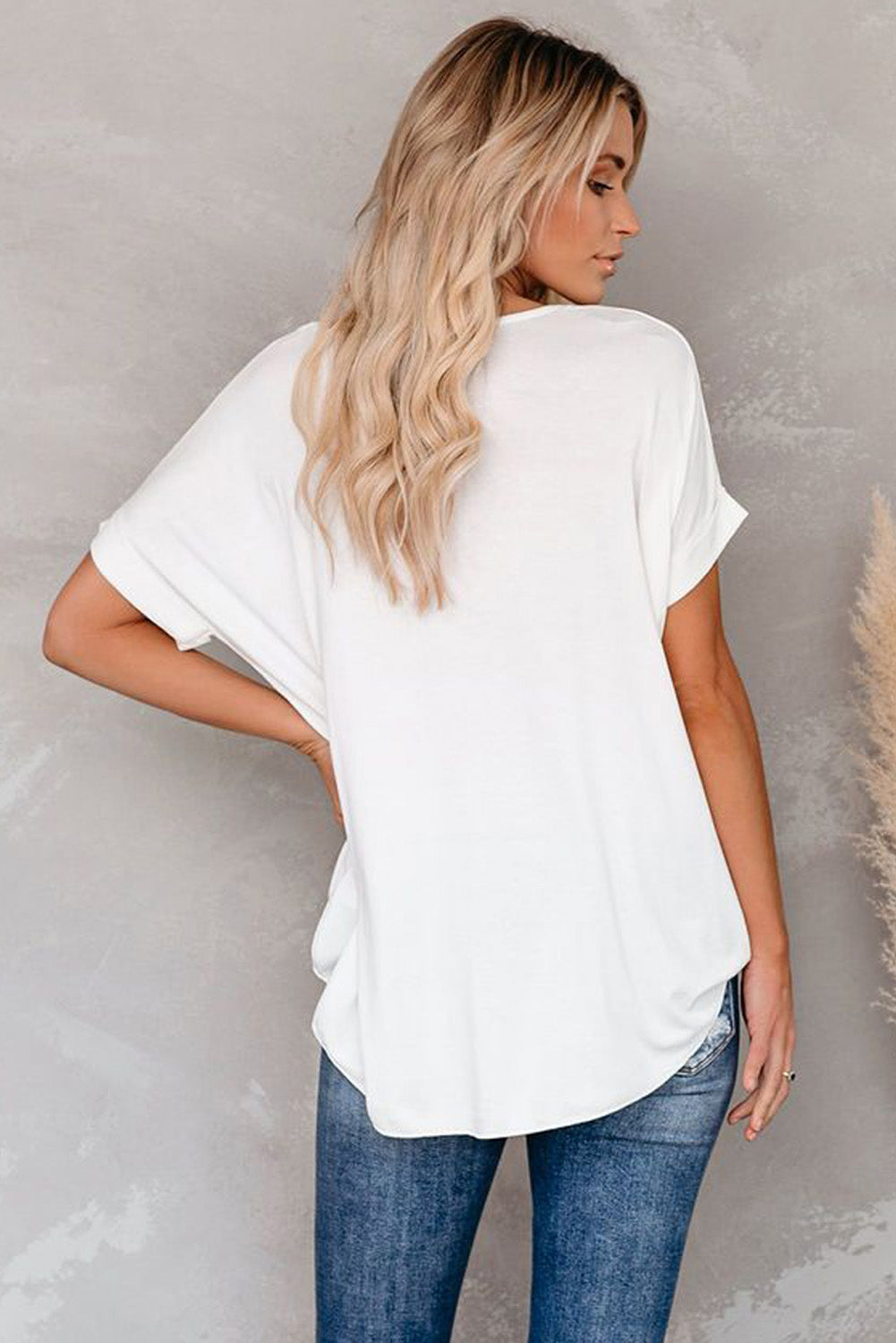 White short sleeves drape knit top with v-neckline and cuffed sleeves, showcasing a chic hi-lo hem design.