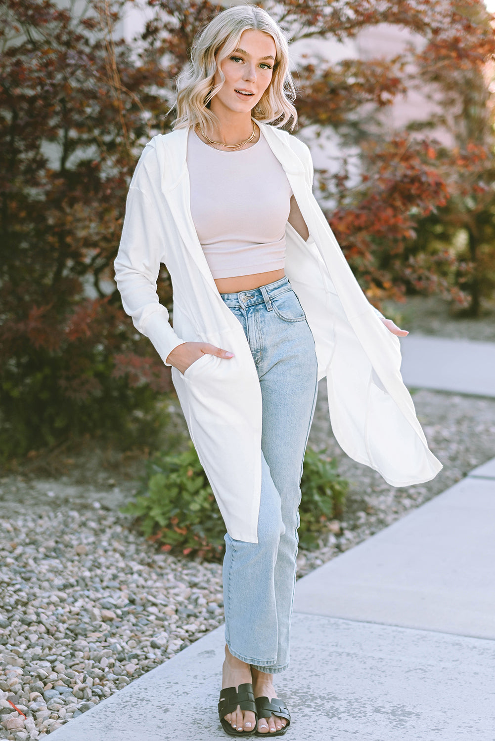 A stylish white hooded cardigan with side splits, featuring two pockets and a long design, perfect for modern women's fashion.