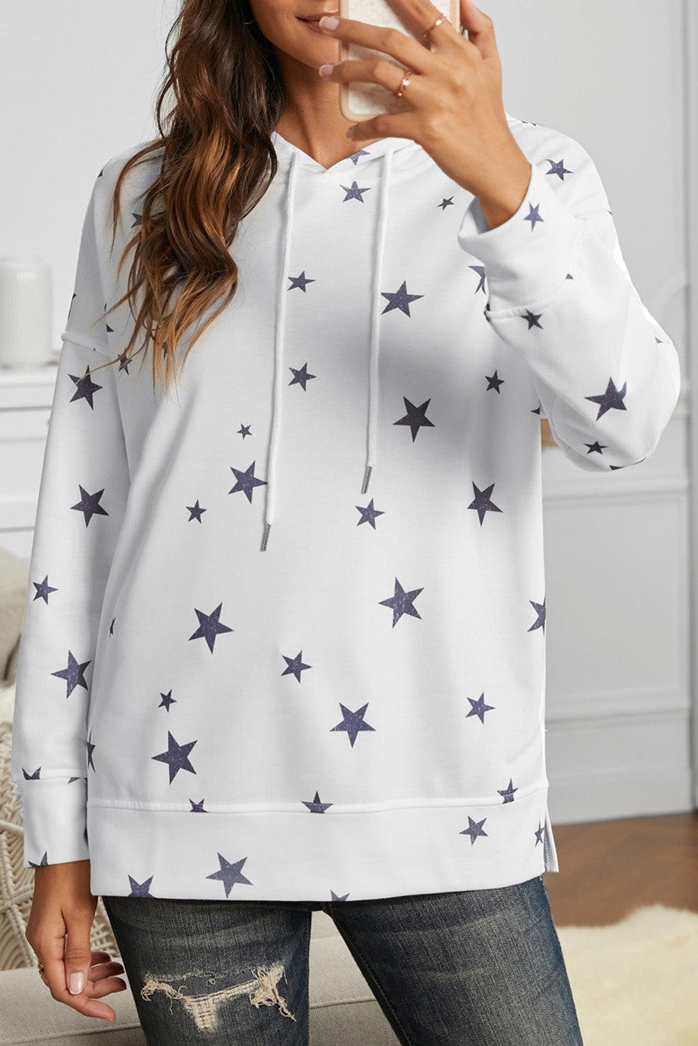 A stylish white hoodie featuring a star print design and side slits, perfect for casual wear.