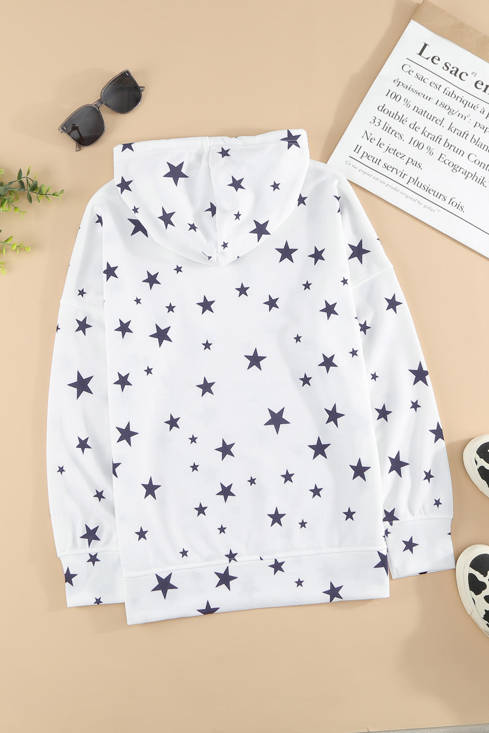 A stylish white hoodie featuring a star print design and side slits, perfect for casual wear.