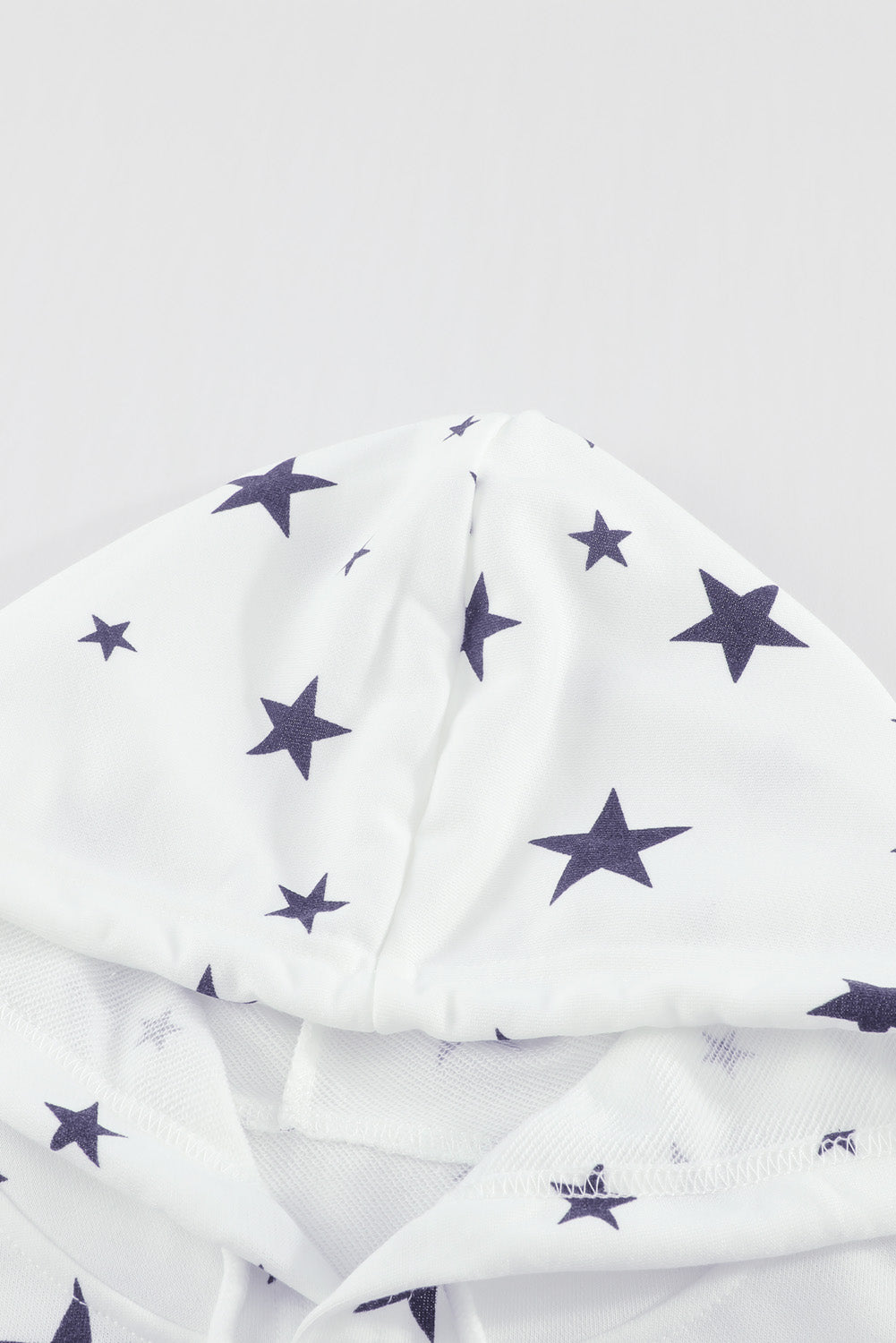 A stylish white hoodie featuring a star print design and side slits, perfect for casual wear.