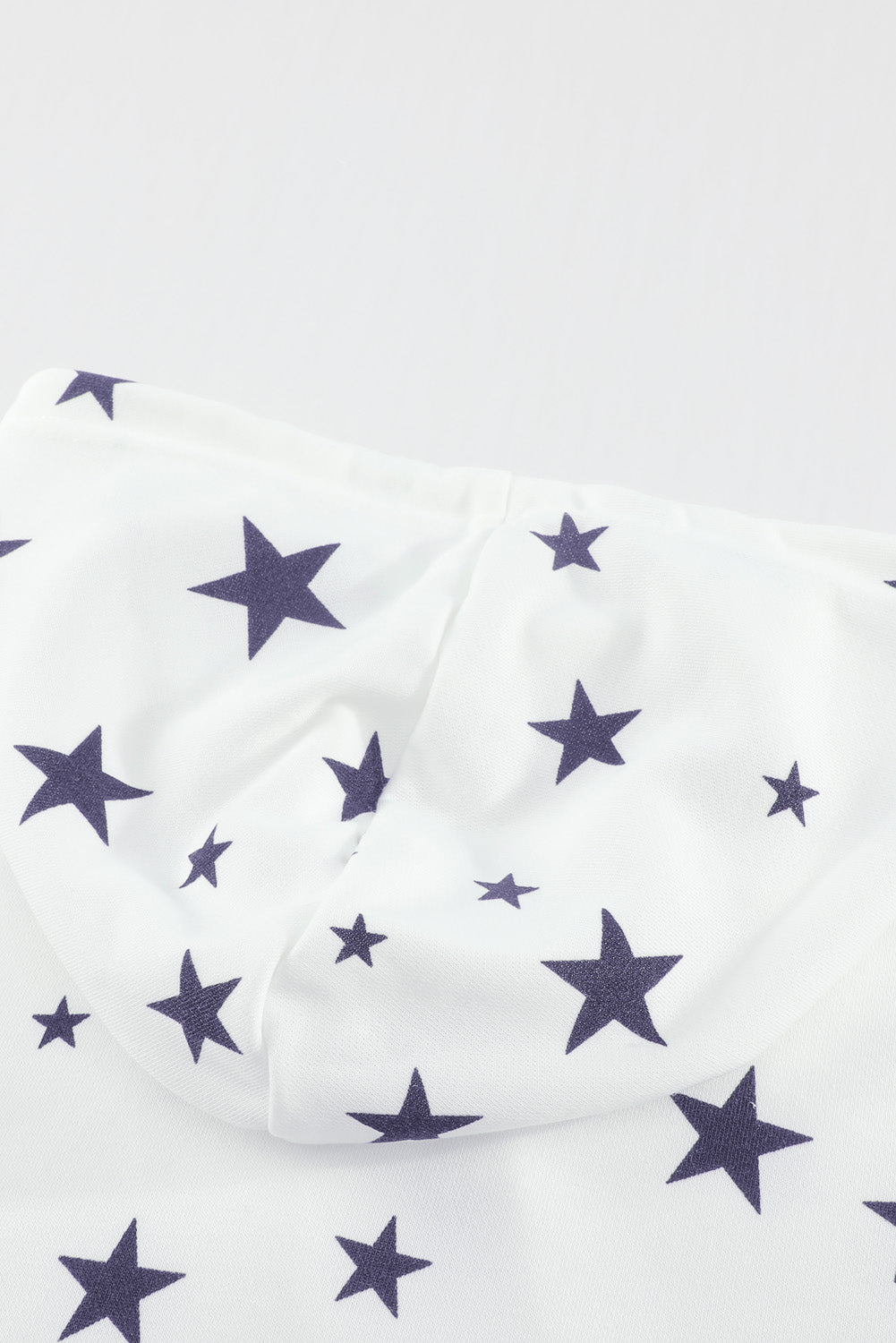 A stylish white hoodie featuring a star print design and side slits, perfect for casual wear.