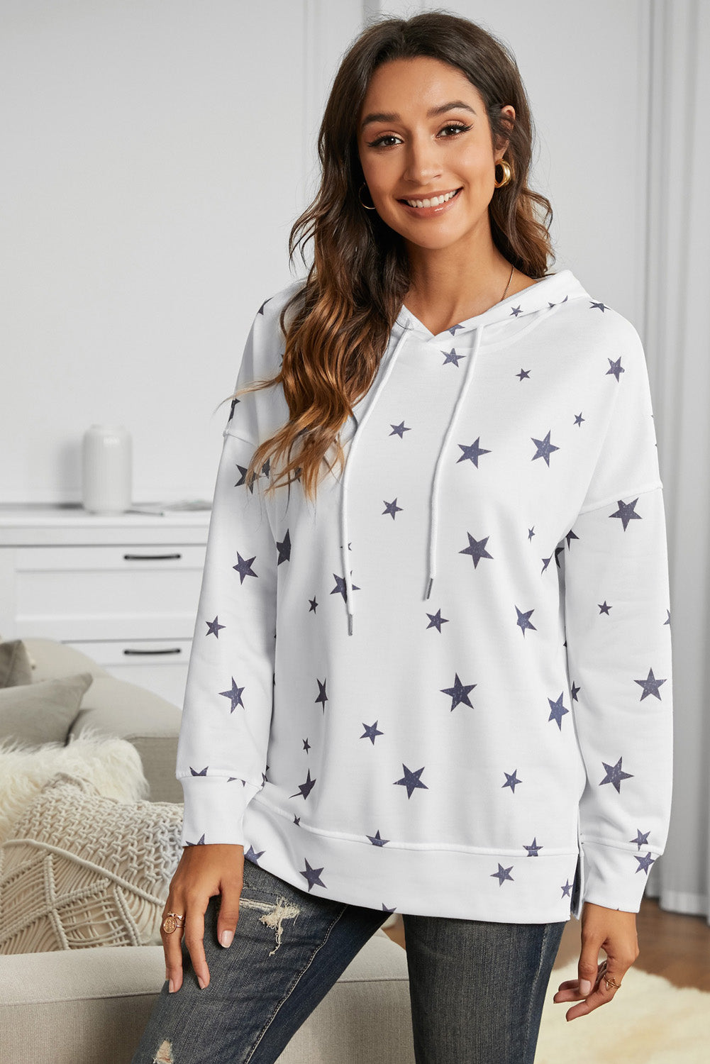 A stylish white hoodie featuring a star print design and side slits, perfect for casual wear.