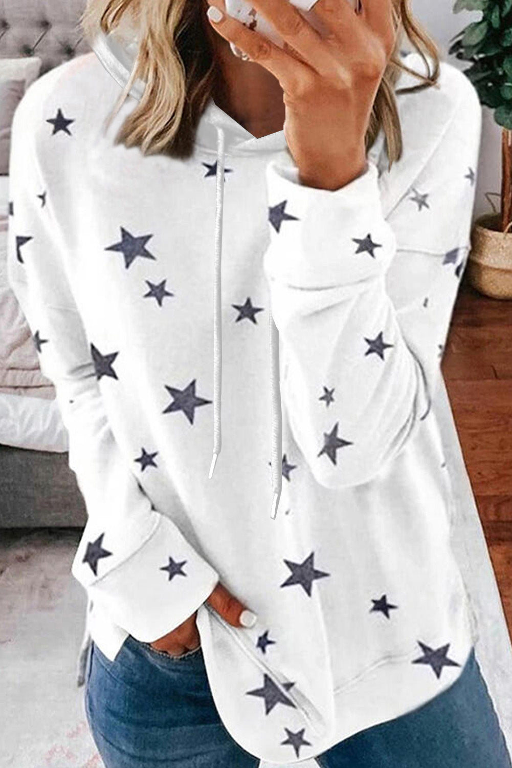 A stylish white hoodie featuring a star print design and side slits, perfect for casual wear.