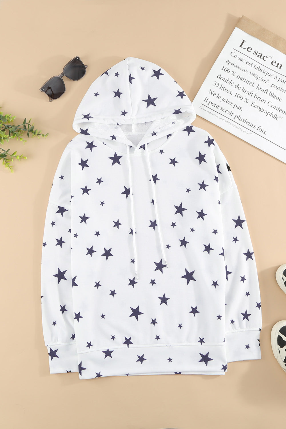 A stylish white hoodie featuring a star print design and side slits, perfect for casual wear.