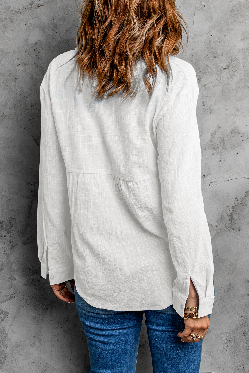 A stylish white textured solid color basic shirt featuring a button closure and collar, showcasing its elegant design and lightweight fabric.