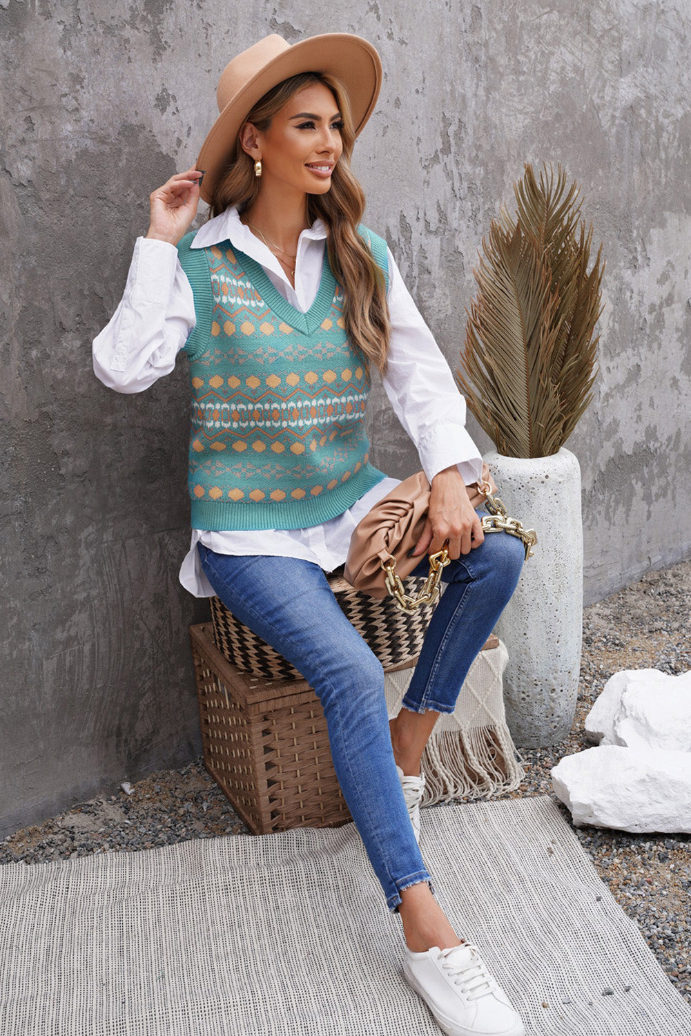 A stylish white knitted sweater vest featuring a unique tribal print design, perfect for layering during colder months.