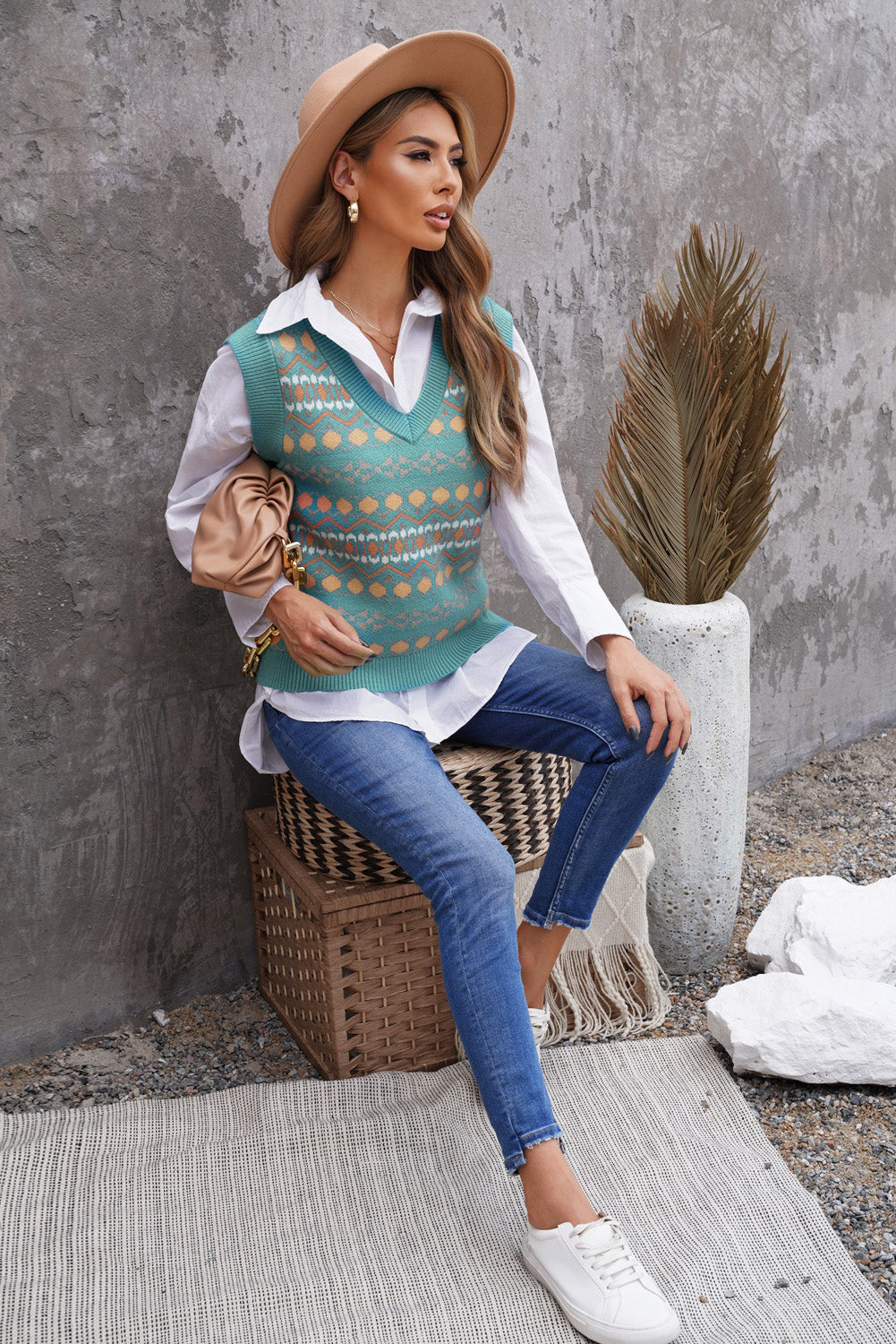 A stylish white knitted sweater vest featuring a unique tribal print design, perfect for layering during colder months.