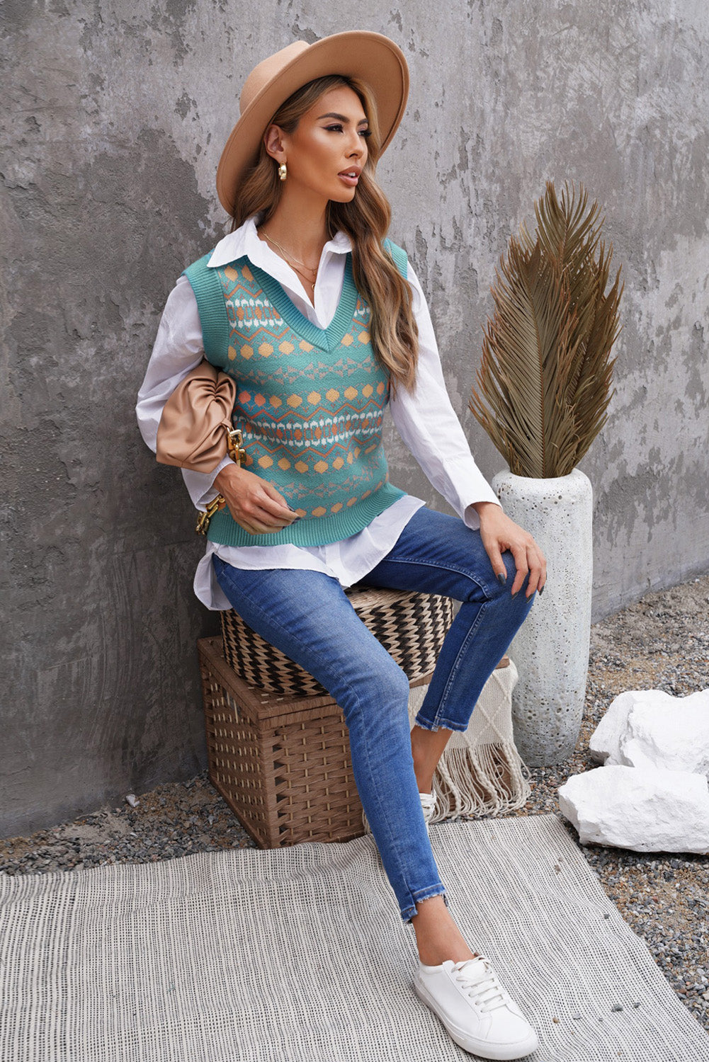 A stylish white knitted sweater vest featuring a unique tribal print design, perfect for layering during colder months.